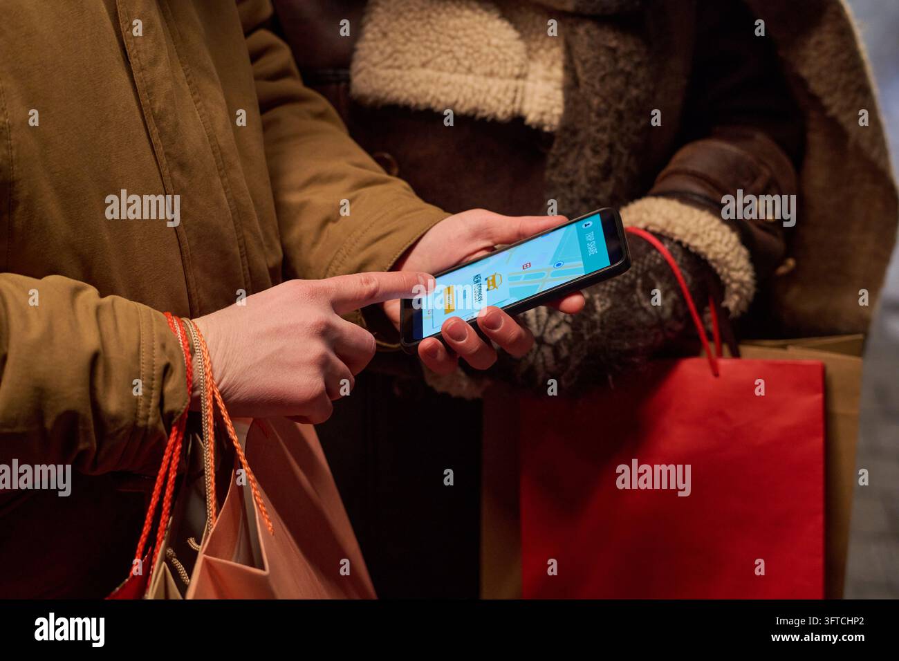 Uomo che prenota un taxi di ride sharing sullo smartphone dopo lo shopping Foto Stock
