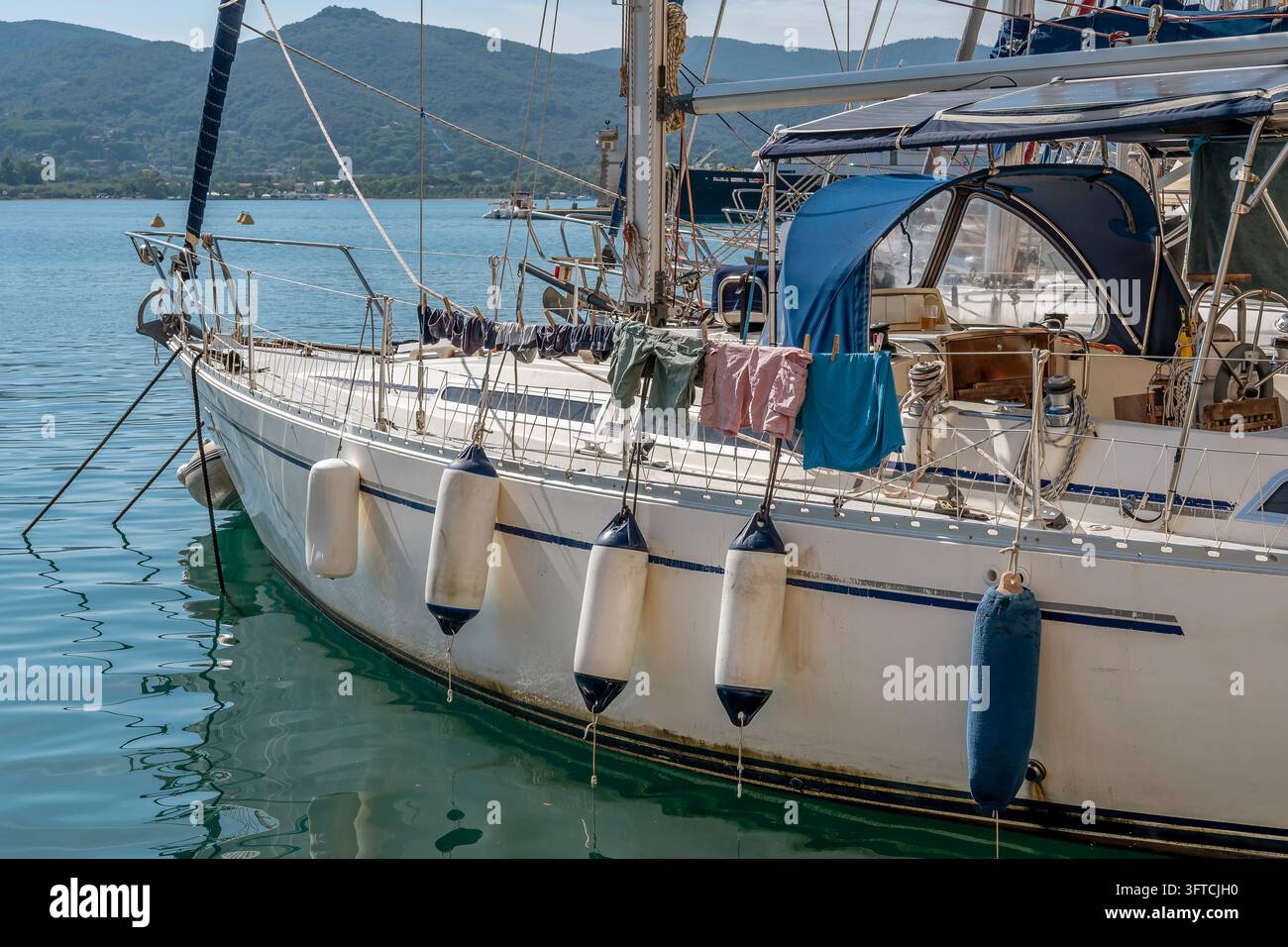 Il bucato è appeso ad asciugare su una barca a vela ormeggiata nel porto di Portoferraio, Italia Foto Stock