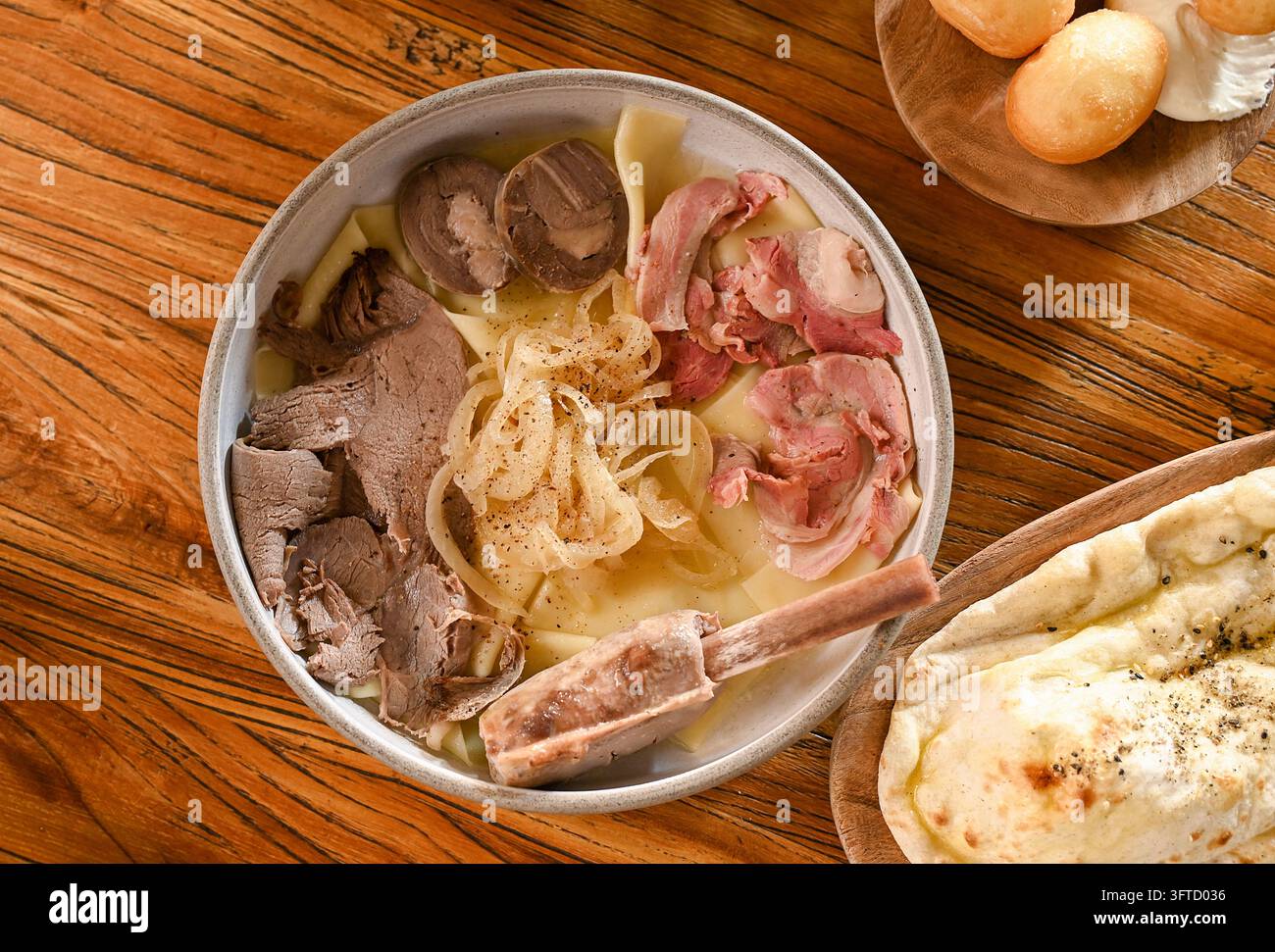 Beshbarmak kazako tradizionale con carne bollita, noodles e cipolle su tavolo di legno Foto Stock