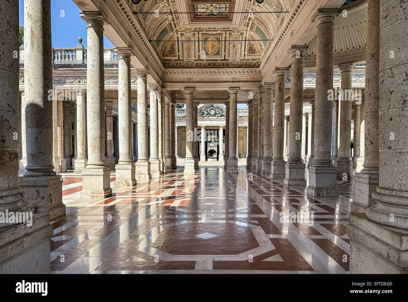 Colonnato monumentale a Montecatini Terme, Toscana, Italia, con colonne di pietra classiche, soffitti ornati e pavimenti in marmo geometrico. Foto Stock