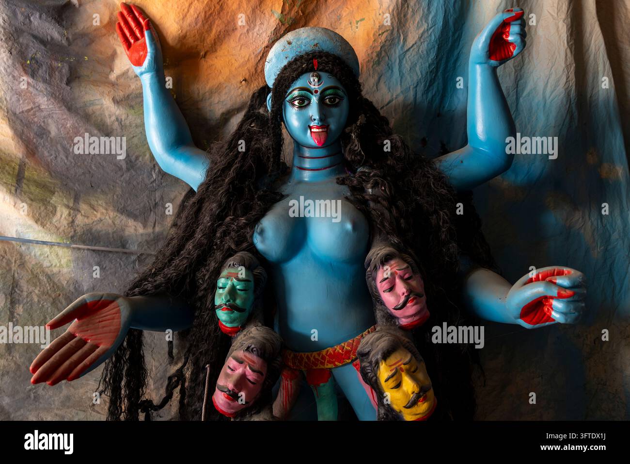 Idolo dipinto di una dea blu con braccia alzate, lingua rossa e capelli fluenti in una bottega nel distretto di Kumartuli, Bengala Occidentale, Kolkata, India Foto Stock