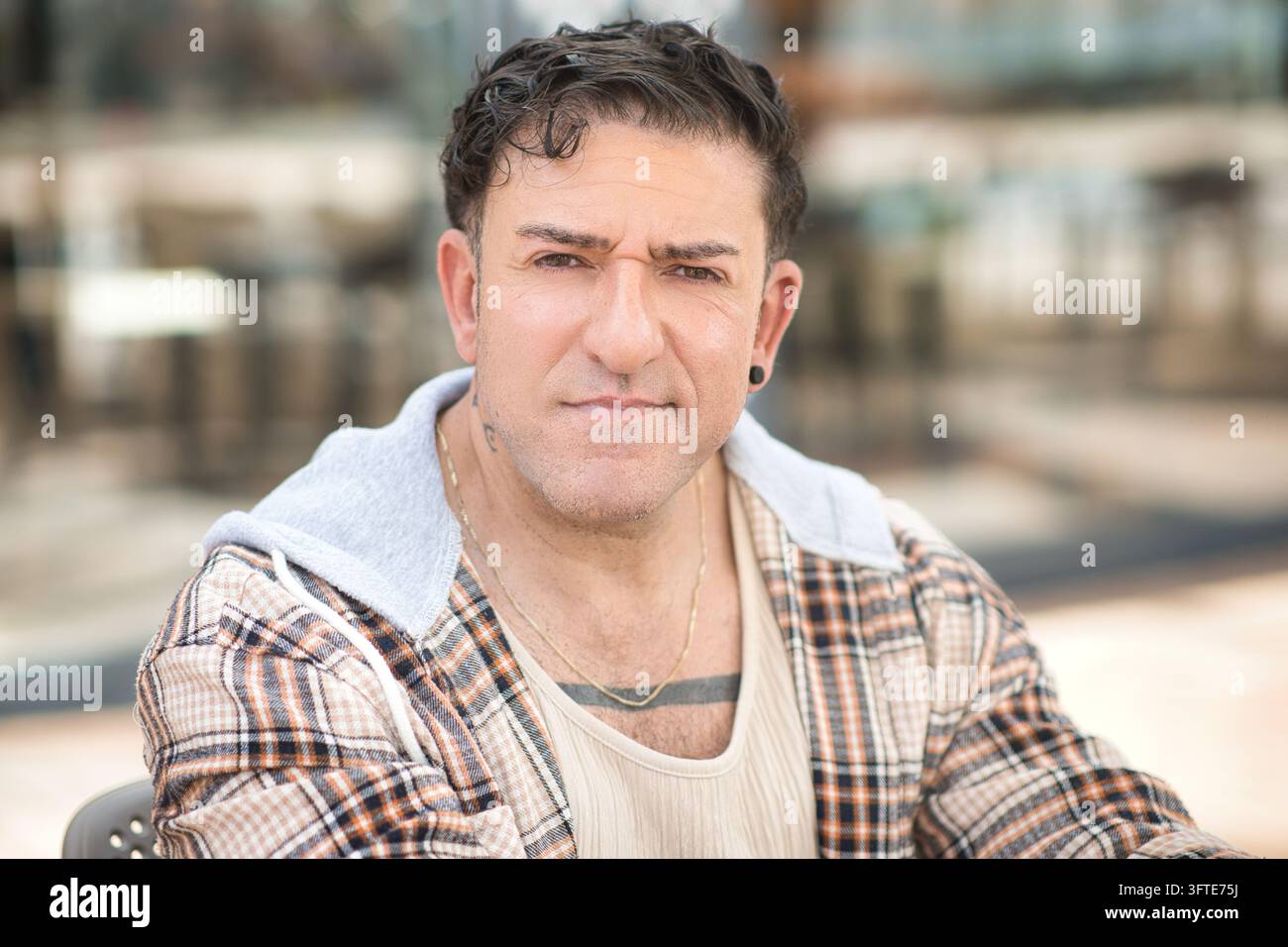 Uomo gay maturo e sicuro di sé che guarda la fotocamera per un profilo di app di incontri all'aperto Foto Stock