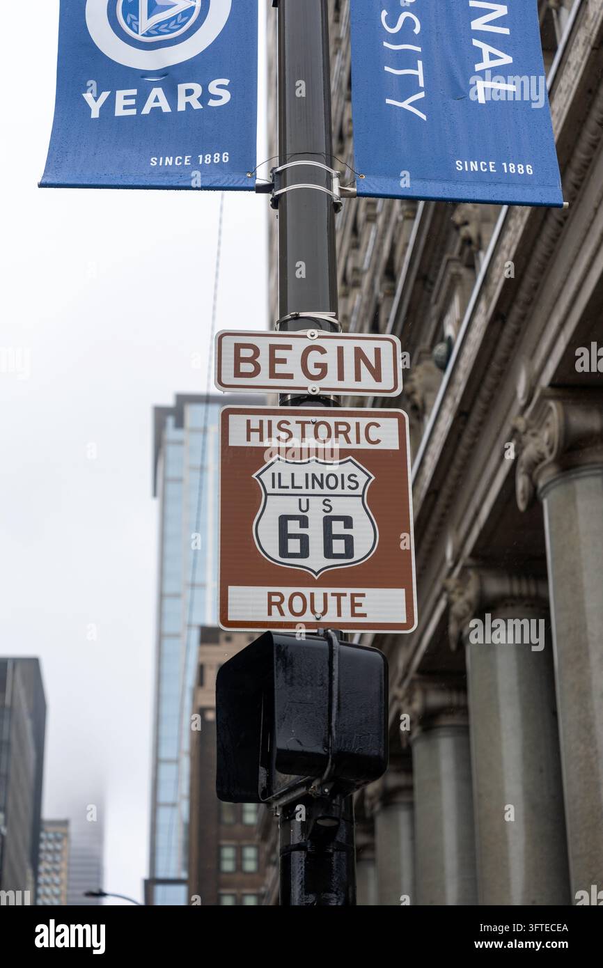 Insegna dell'inizio della storica Route 66 su una strada nel centro di Chicago, Illinois, USA. Primo piano del punto di partenza iconico della leggendaria autostrada americana Foto Stock