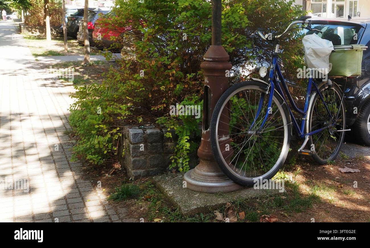 Bicicletta da pendolare blu accanto a un lampione Foto Stock