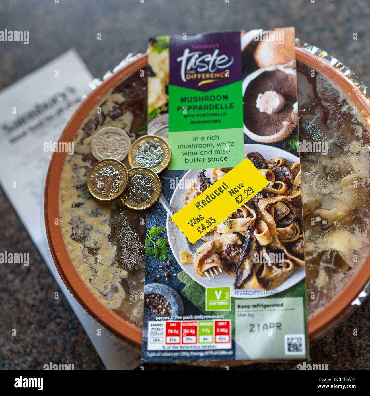 Adesivi gialli ridotti su alimenti di un supermercato nel Regno Unito con banconote e una ricevuta. Foto Stock