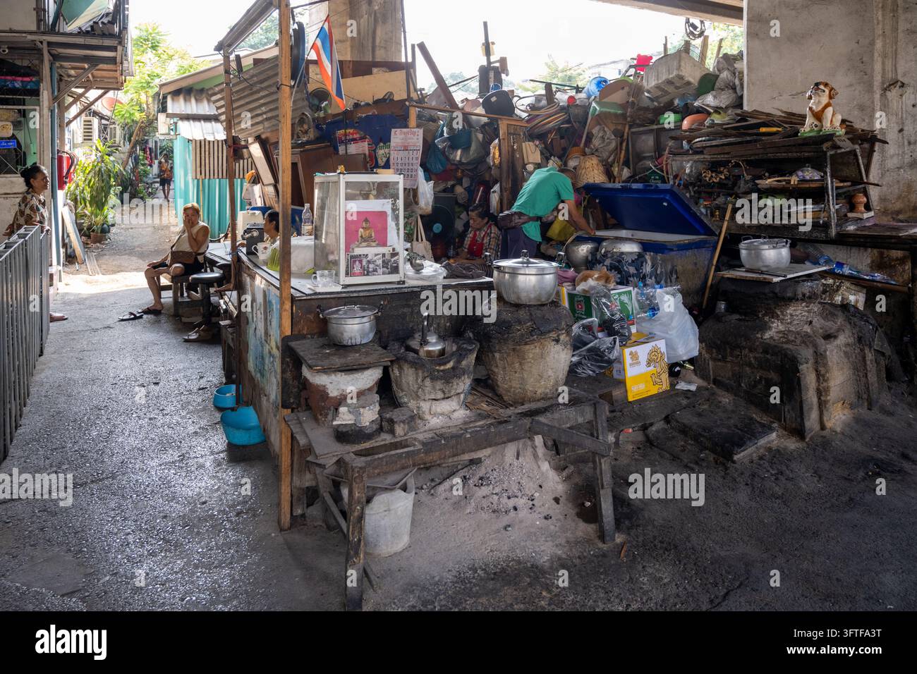 Khlong Toei, Bangkok, Thailandia, 19 gennaio 2026. I residenti occupano una cucina all'aperto improvvisata e un'area abitativa sotto infrastrutture sopraelevate. Foto Stock