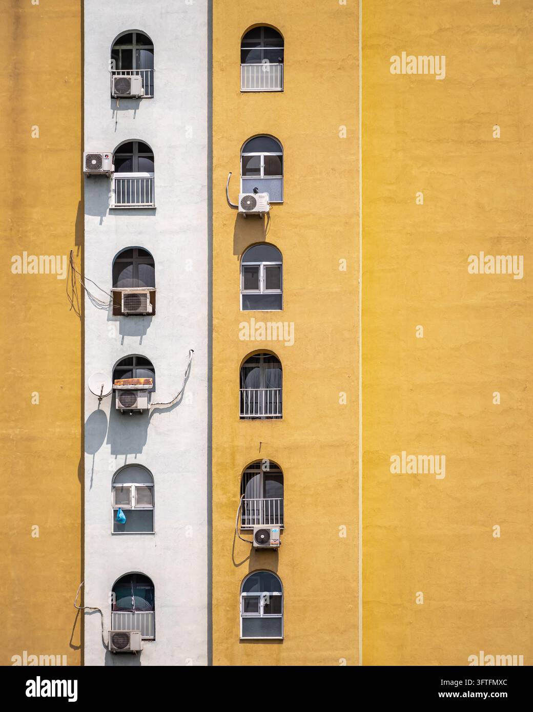 Dettaglio architettonico astratto verticale con un muro giallo brillante e elementi decorativi. Foto Stock