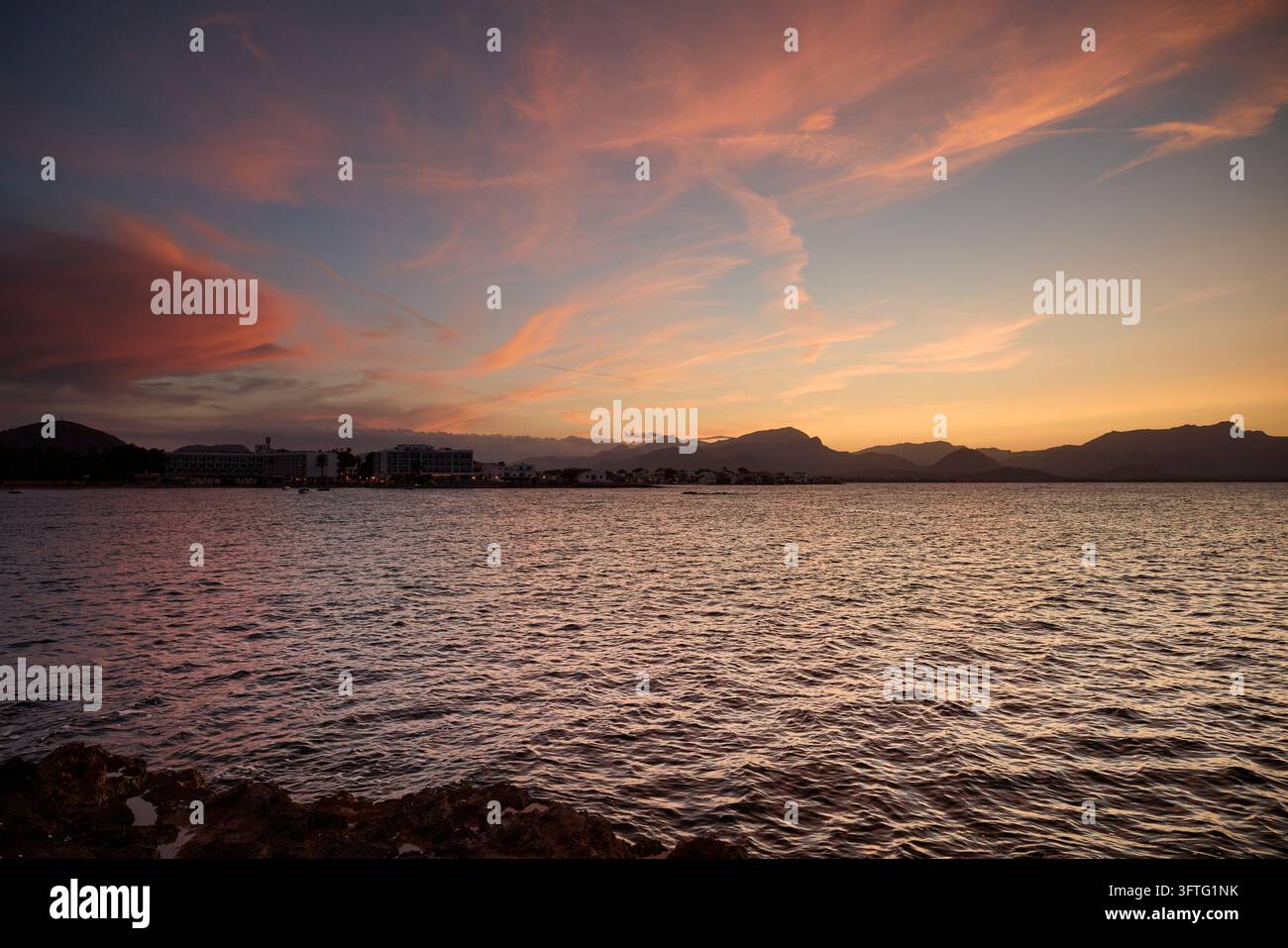 Bellissimo cielo al tramonto sul mare Mediterraneo e sulla località turistica di Port de Pollença Foto Stock