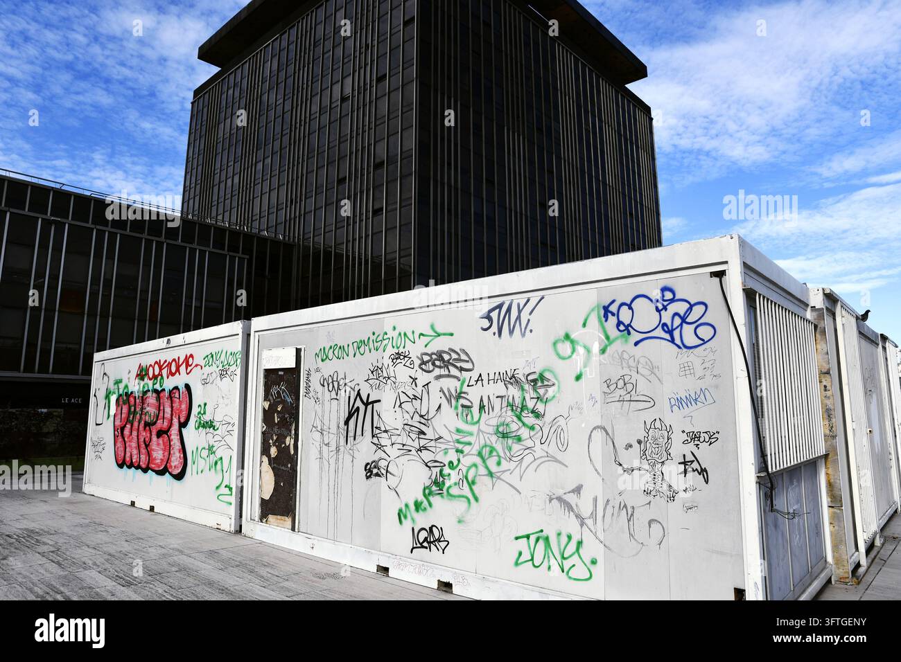 L'edificio dell'ufficio del Tour CIT (Centre International de Temps) e i container per la costruzione coperti di graffiti situati sulla lastra sopra il Montparnasse Foto Stock