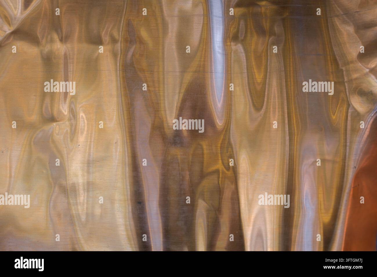 Foglio di rame flessibile. Sfondo di rame astratto con riflessi e transizioni di colore metalliche. Messa a fuoco selettiva. Spazio per la copia. Foto Stock