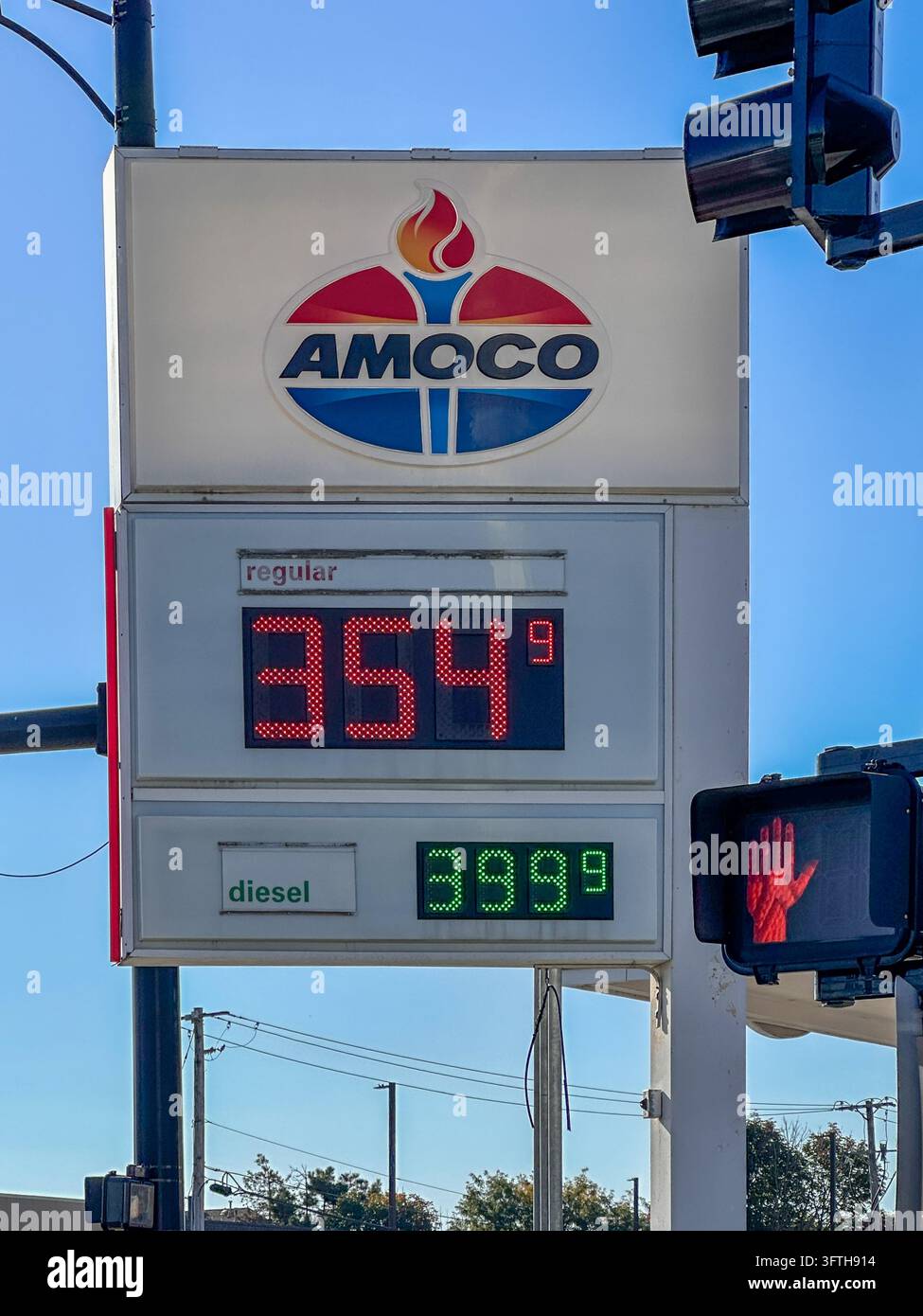 Insegna della stazione di servizio Amoco con prezzi dei carburanti contro un cielo blu. Hobart, IN USA, 5 ottobre 2025 - Immagine stock catturata con smartphone