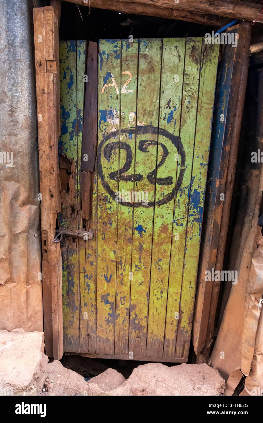 Porta di legno verde consumata con il numero 22 dipinto e A2 nell'area di Kibera, Contea di Nairobi, Nairobi, Kenya Foto Stock
