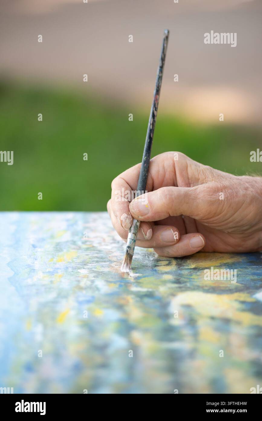 Vecchio artista dipinge Foto Stock