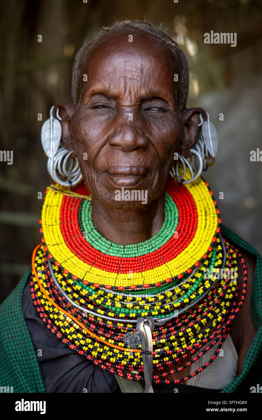 Prima piano di una donna anziana della tribù Turkana con orecchini d'argento, una collana di perle e uno scialle a quadri, Contea di Marsabit, Loiyangalani, Kenya Foto Stock