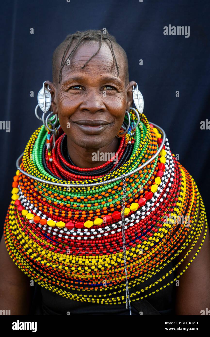 Donna sorridente della tribù Turkana con capelli intrecciati, orecchini di foglia d'argento e collane di perle colorate, Contea di Marsabit, Loiyangalani, Kenya Foto Stock