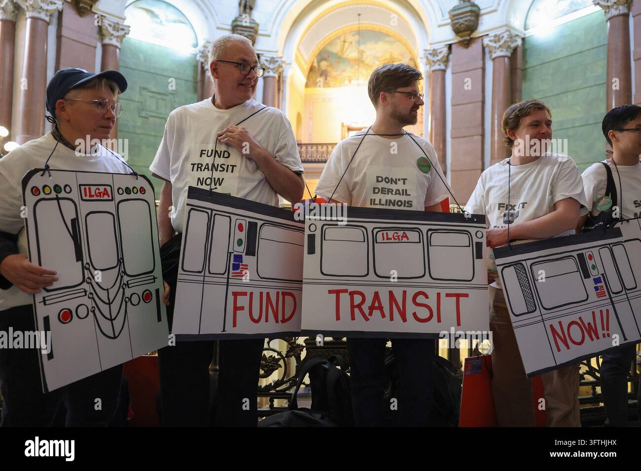 Un gruppo di persone indossa magliette a tema trasporti e ritagli di cartone mentre aspettano di consegnare petizioni ai legislatori durante la sessione legislativa al Campidoglio dell'Illinois, martedì 28 ottobre 2025, a Springfield, Illinois. (Foto di John J. Kim/Chicago Tribune/TNS/Sipa USA) Foto Stock