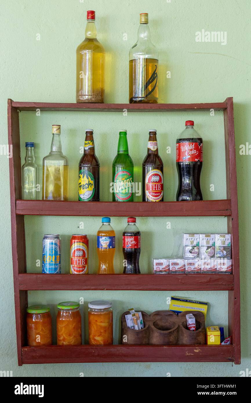 Scaffali di legno espongono bevande in bottiglia, bevande in lattina e piccoli prodotti in vendita all'interno di un negozio locale, Melaky, Bekopaka, Madagascar Foto Stock