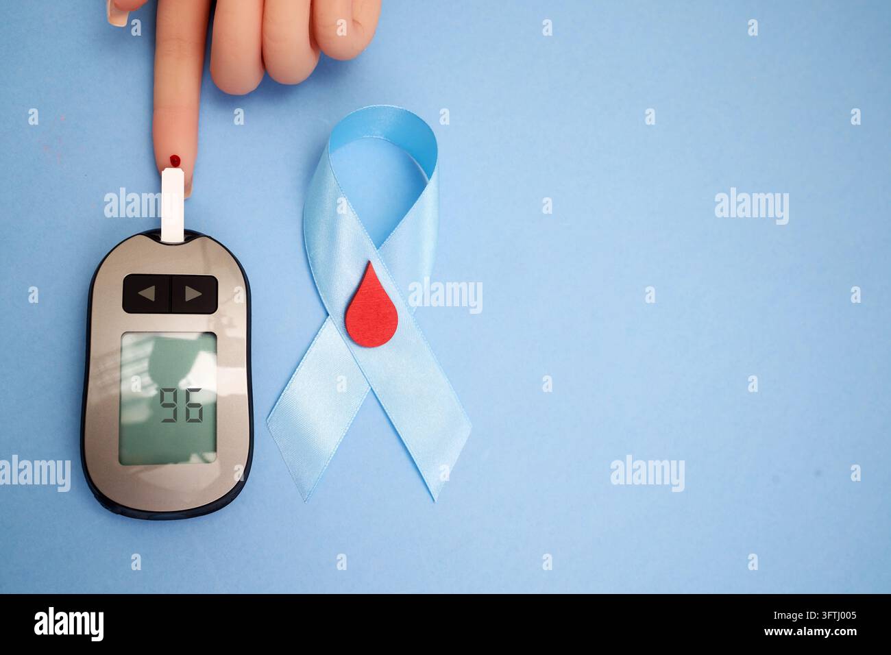Giornata mondiale del diabete. Persona che controlla la glicemia utilizzando un monitor del glucosio per la sensibilizzazione al diabete Foto Stock