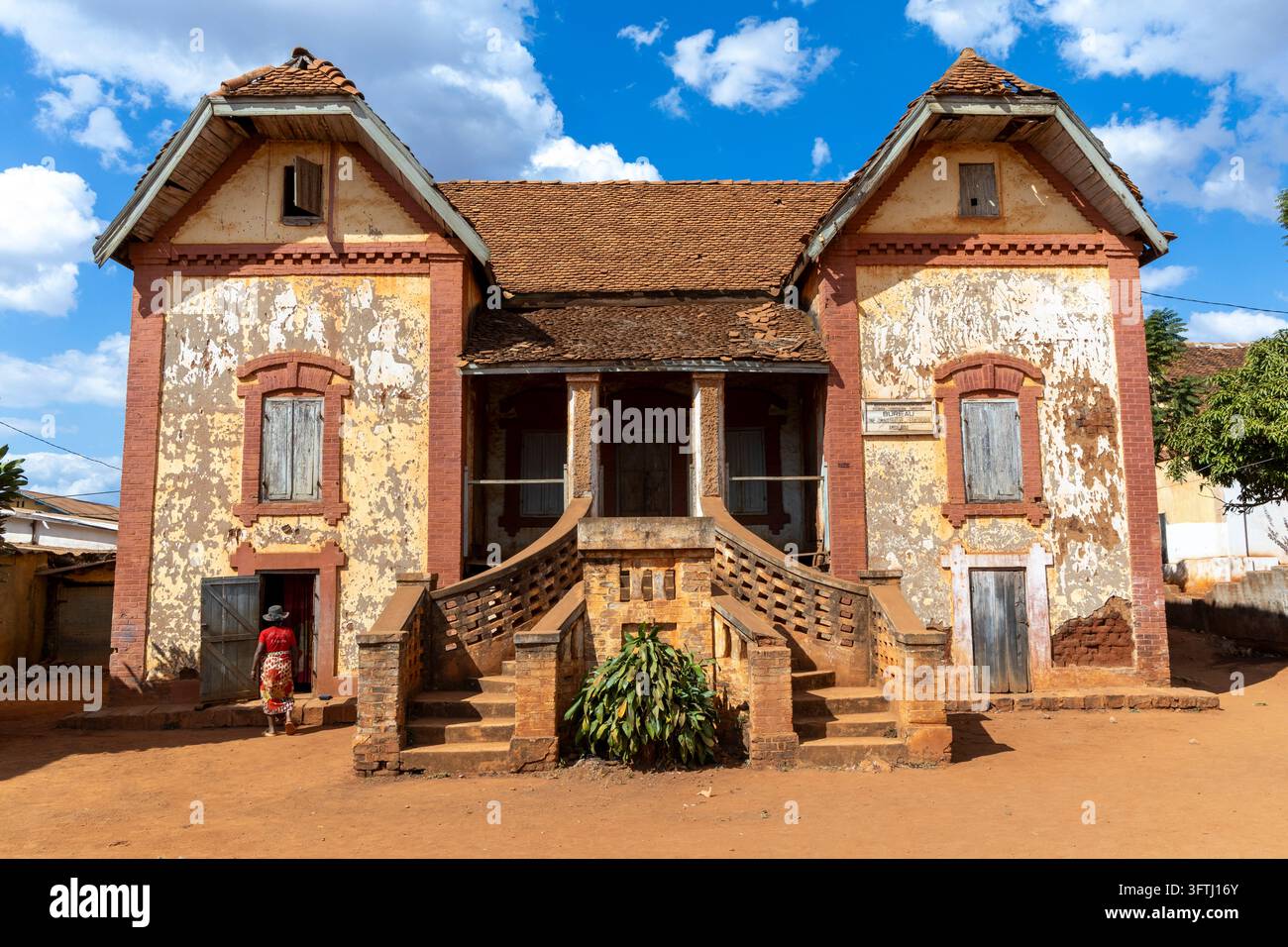 La facciata simmetrica di un edificio coloniale eroso con torri gemelli sopra una scala in mattoni curva, Haute Matsiatra, Ambalavao, Madagascar Foto Stock