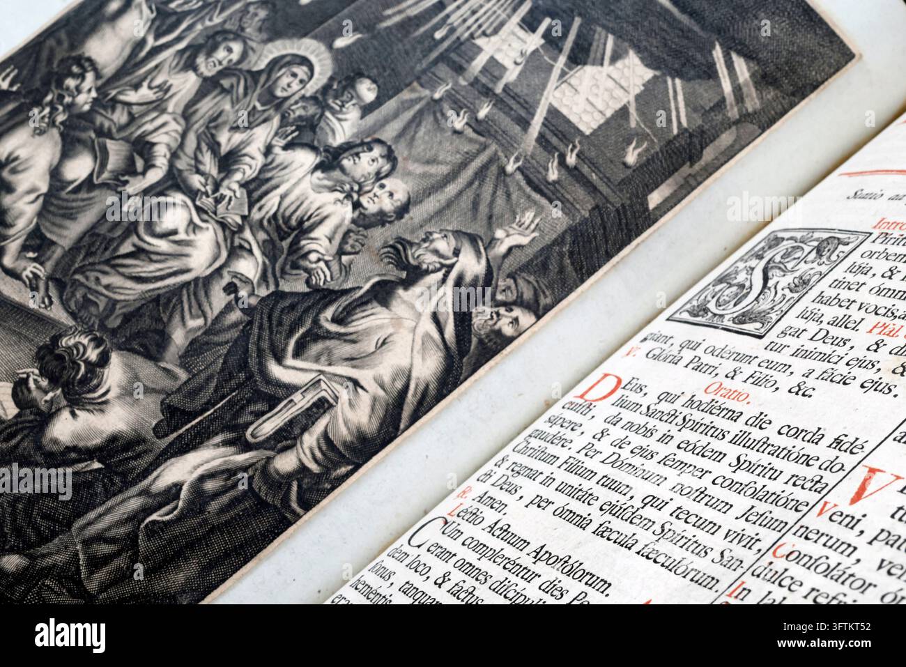 Un antico messale liturgico aperto rivela un'incisione religiosa della Pentecoste accanto a testi latini stampati con iniziali rosse. Foto Stock