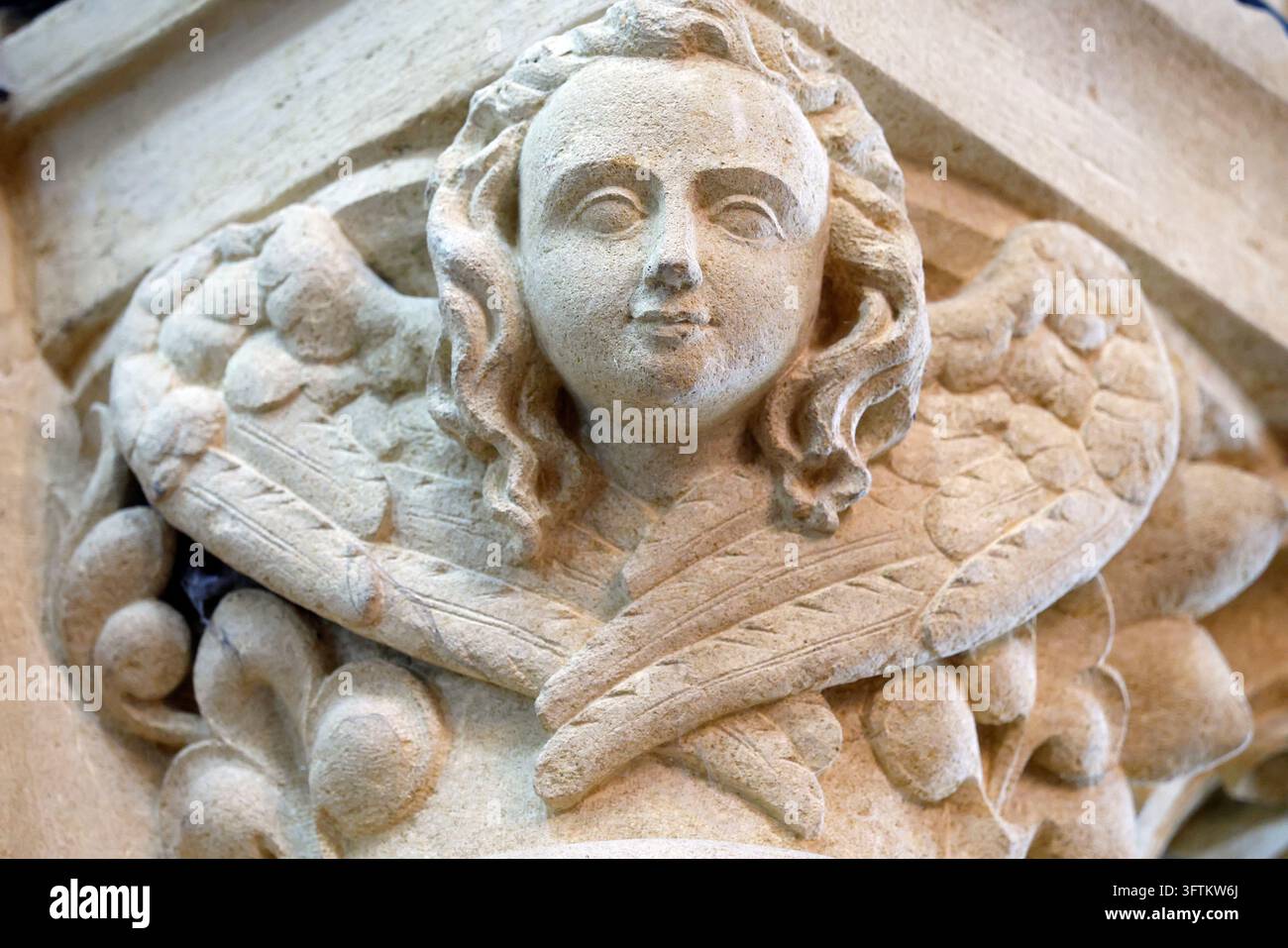 Chiesa di Saint Corneille. Un'antica scultura in calcare di un volto di cherubino con ali incrociate su un capitello. Francia. Foto Stock