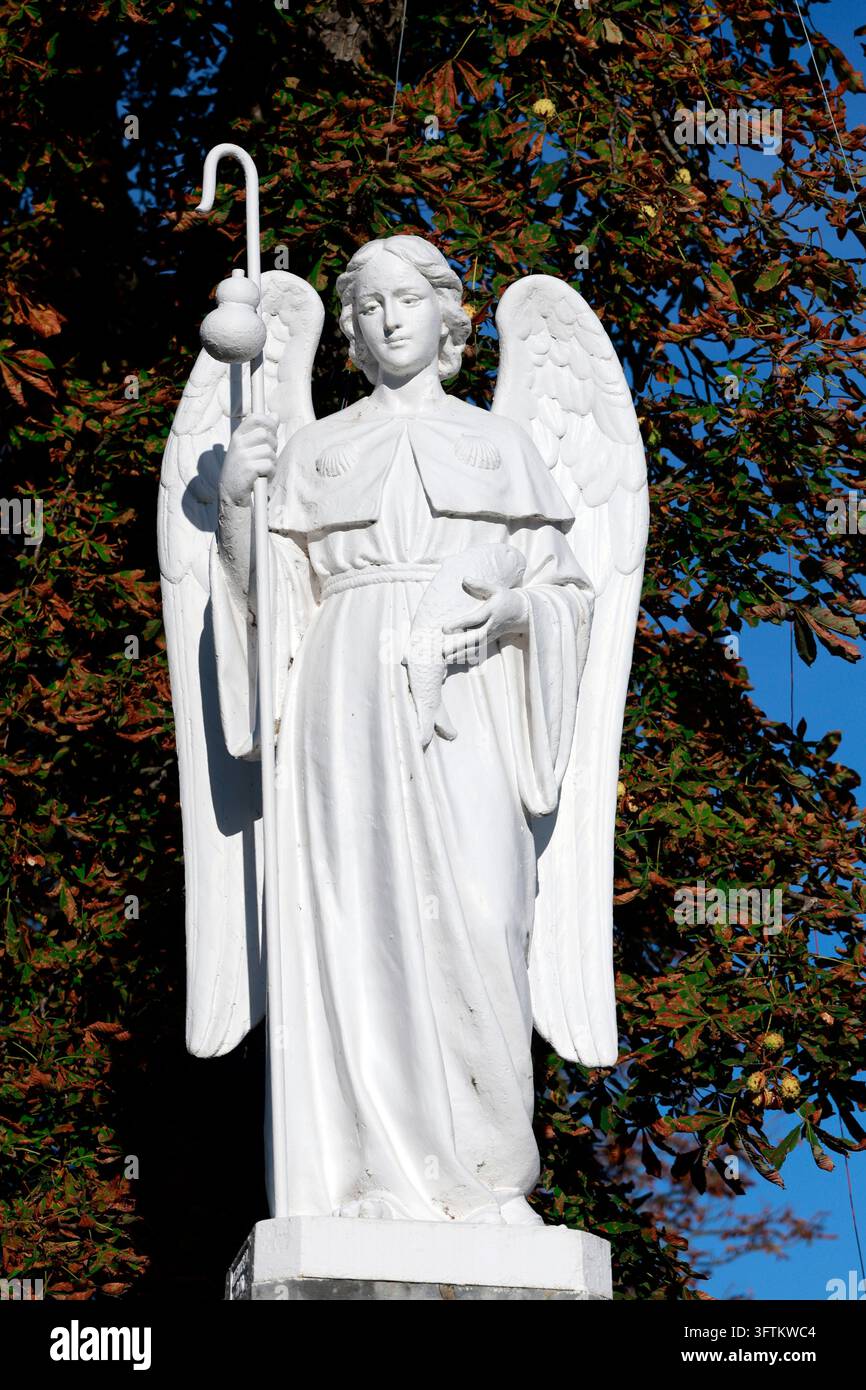 Arcangelo Raffaele che tiene uno scettro, una zucca e un pesce – simboli del pellegrino e della guarigione. Lourdes, Francia. Foto Stock