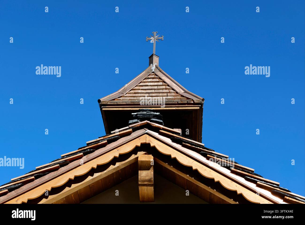 La cappella barocca di Bionnassay. Il campanile in legno e il tetto di ardesia si stagliano contro il cielo blu. Saint-Gervais, Francia. Foto Stock