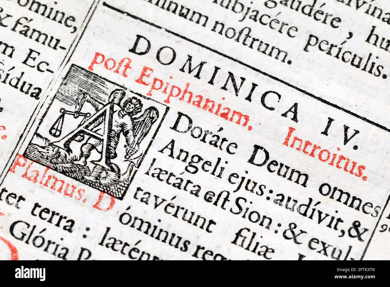 Un primo piano mostra una pagina di un antico messale liturgico stampato in latino, con rubriche rosse e una lettera iniziale adornata dall'Arcangelo San Mi Foto Stock
