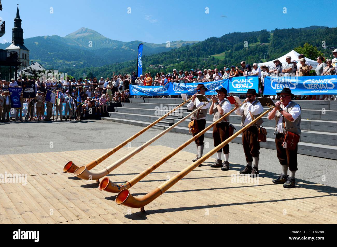 Musici in costume tradizionale eseguono un pezzo all'alphorno durante il Festival delle Guide di Saint Gervais. Saint Gervais. Francia. Foto Stock