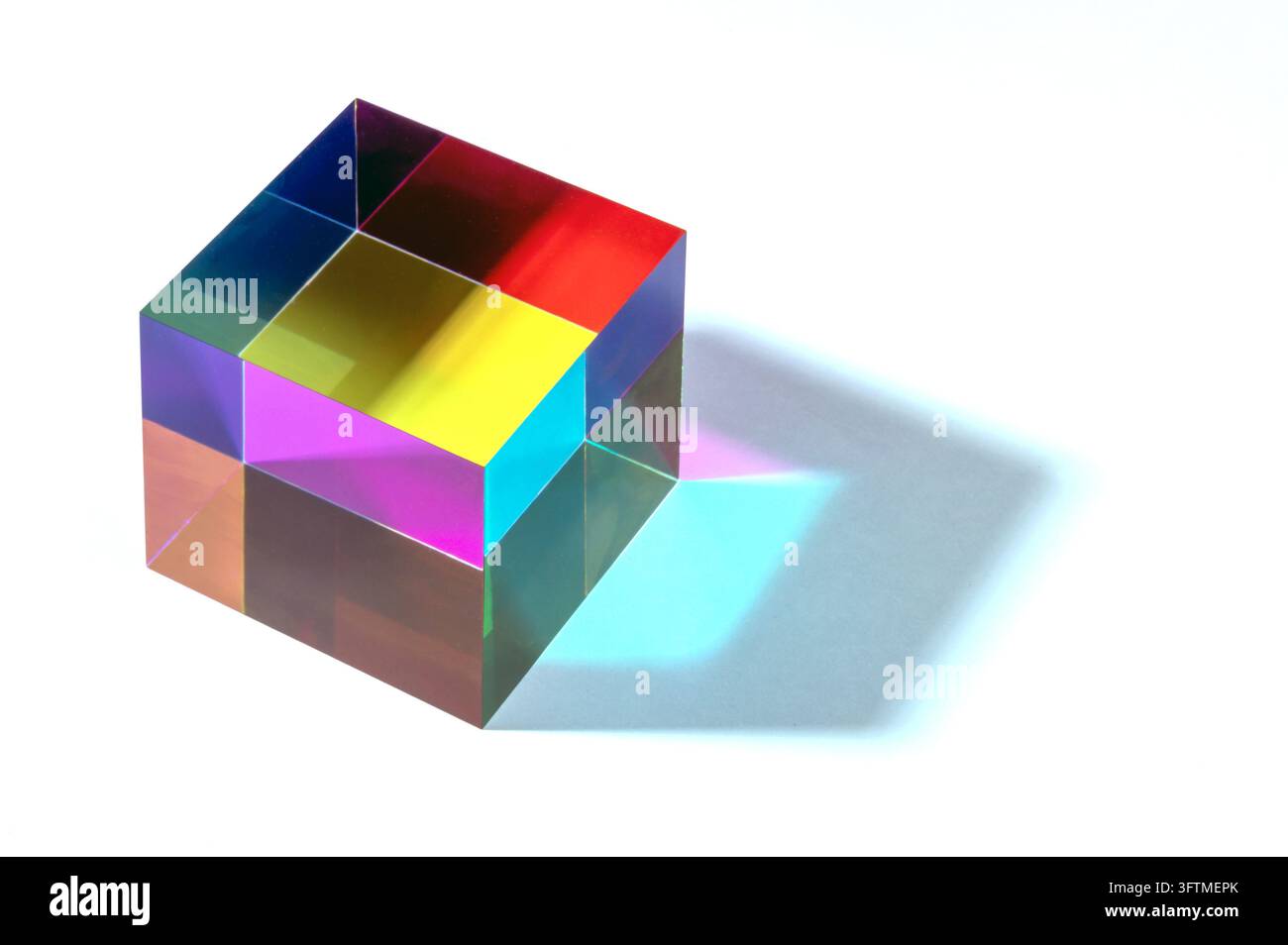 Cubo prismatico che genera uno spettro di luce con colori vivaci e un'ombra blu su sfondo bianco Foto Stock