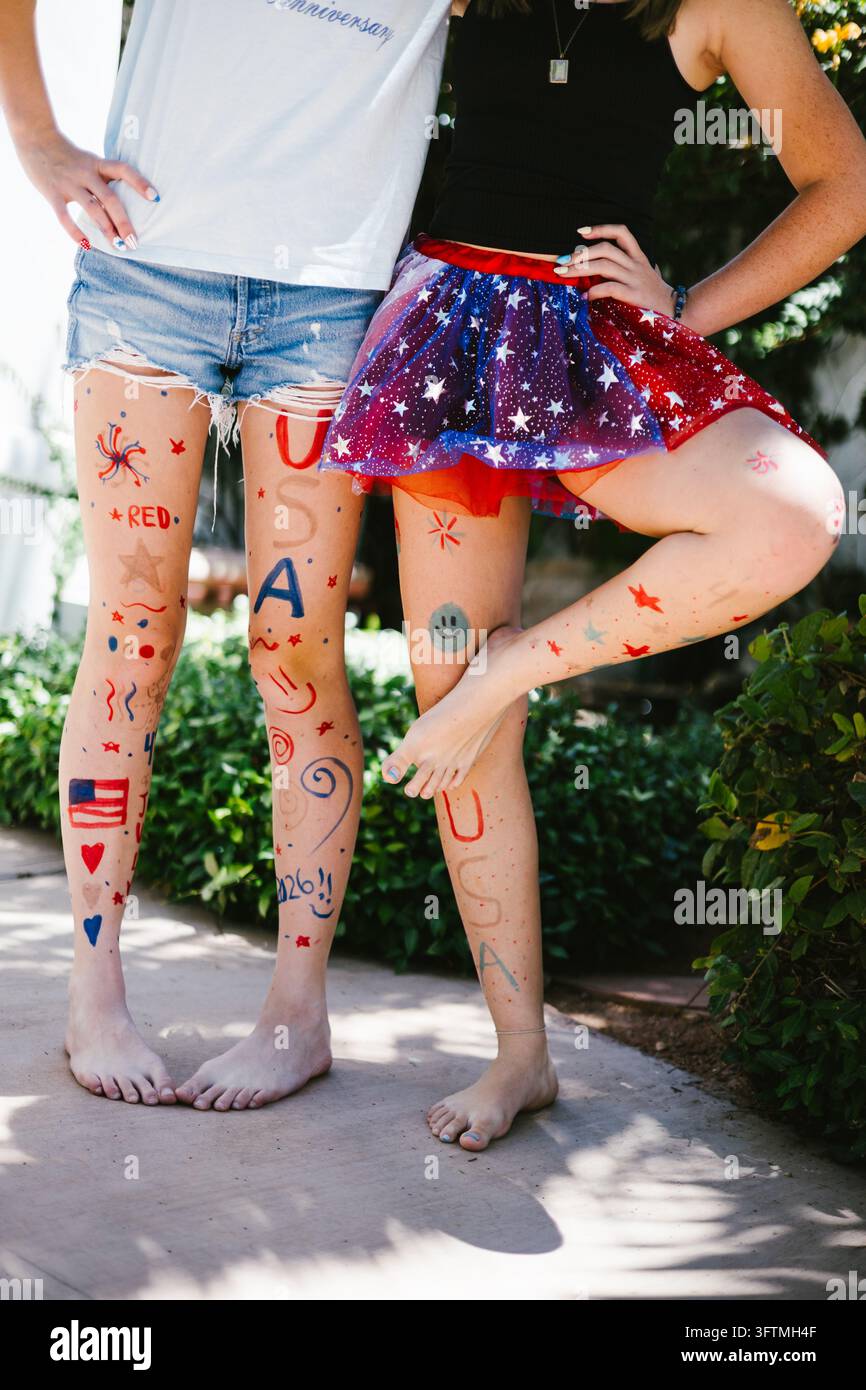 Amici adolescenti con le gambe dipinte per una festa del 4 luglio Foto Stock