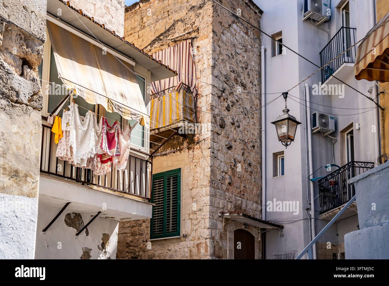 Balcone residenziale tradizionale con biancheria appesa ad asciugare sopra una stretta strada a Bari Vecchia (la vecchia città di Bari), Puglia, Italia Foto Stock
