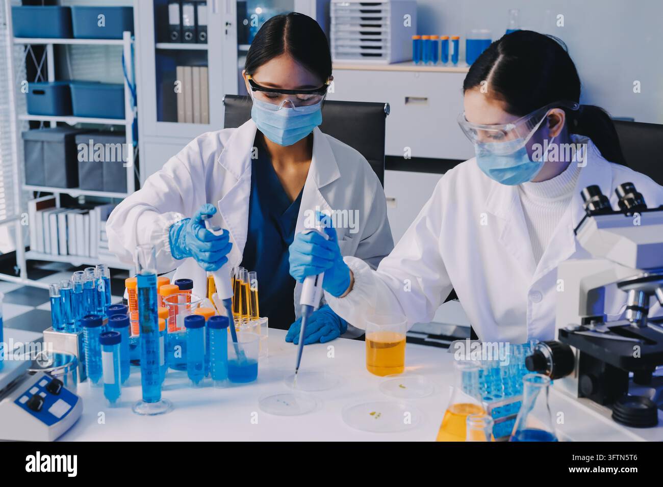 Un ricercatore medico o scientifico o un medico che osservi una provetta di soluzione limpida in un laboratorio Foto Stock