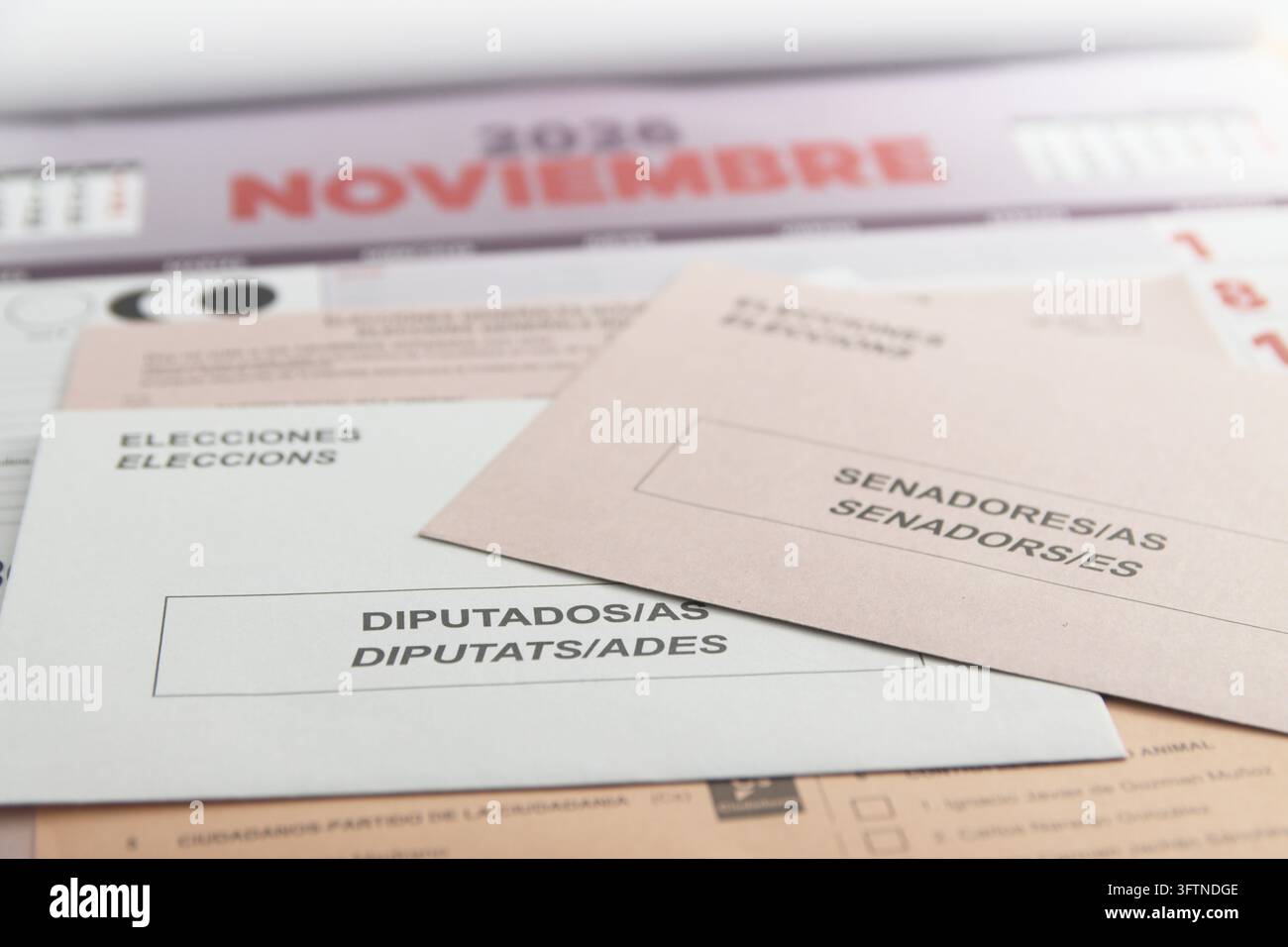 2026. Spagna. Buste contenenti schede di voto bilingue, appoggiate su un calendario di novembre. Foto Stock