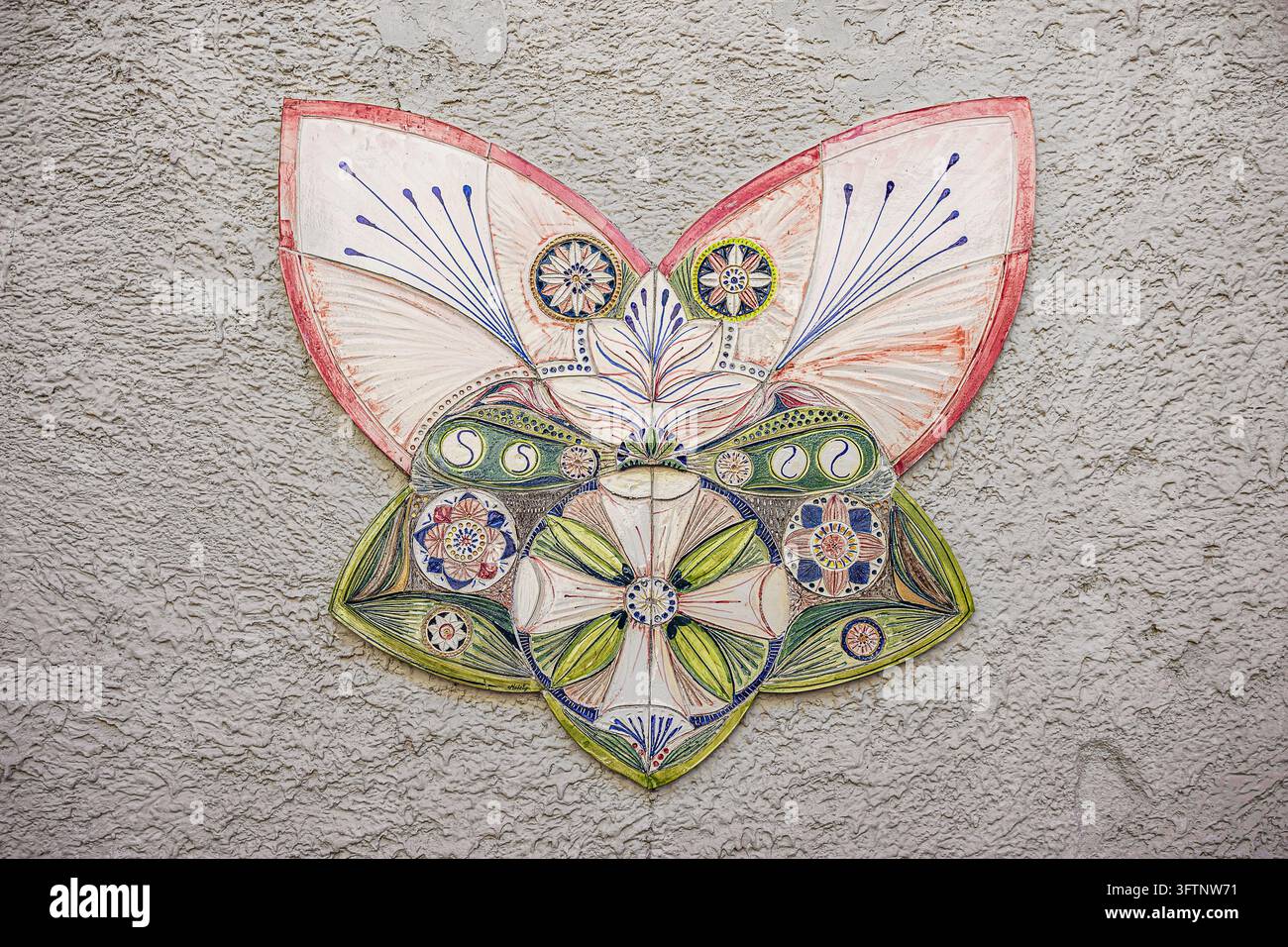 Decorazione murale in ceramica a forma di farfalla su una facciata di casa tradizionale Foto Stock