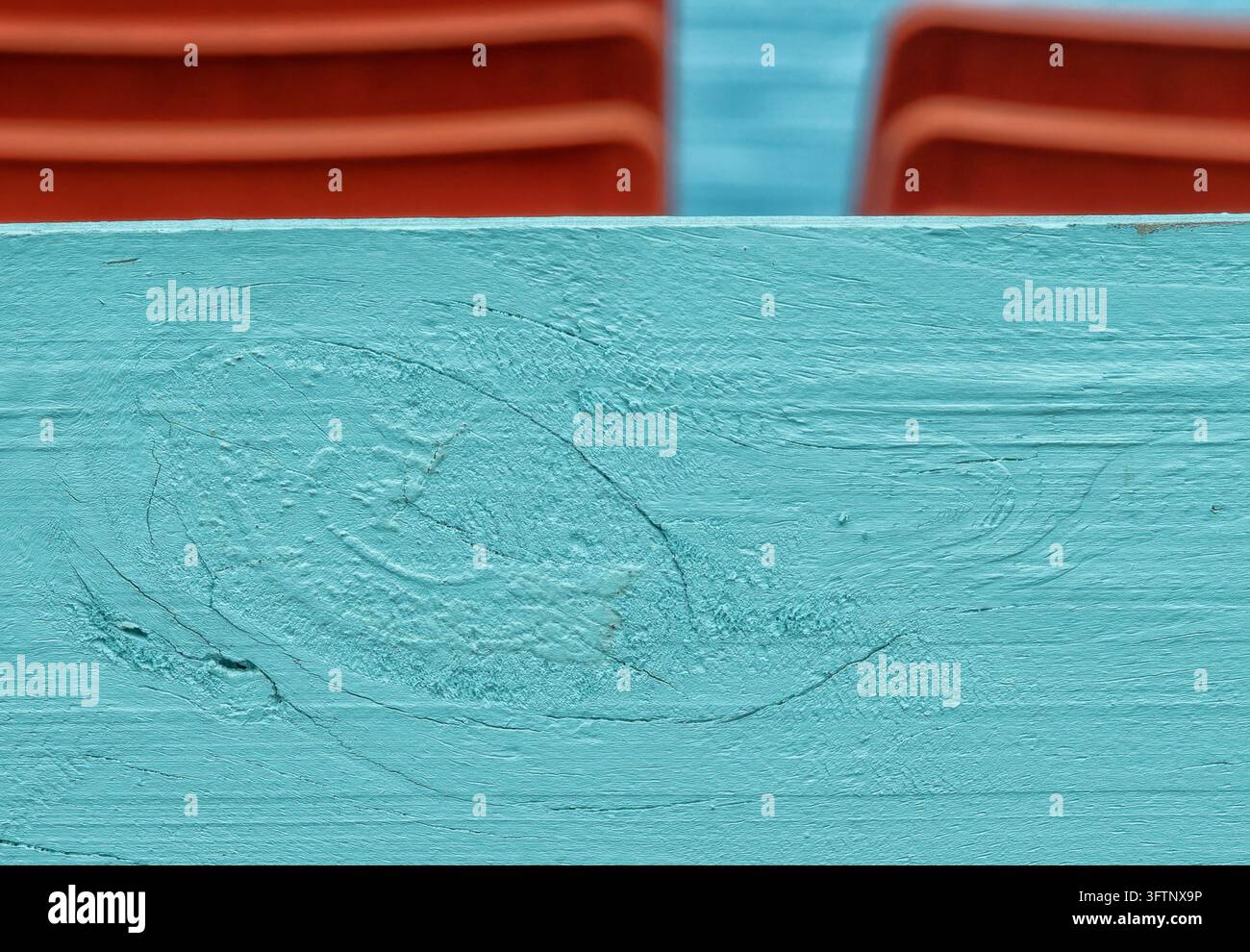 Un primo piano di una tavola di legno dipinta di un colore blu verde o turchese con un nodo di legno ben visibile e una texture di venatura evidente Foto Stock