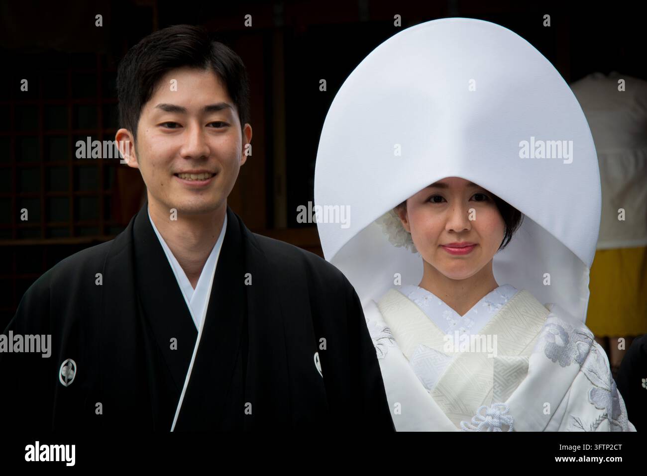Hokaiddo, Giappone – 5 agosto 2018: Ritratto di uno sposo giapponese sorridente in un kimono nero tradizionale e di una sposa che indossa un kimono shiromuku bianco con un Foto Stock