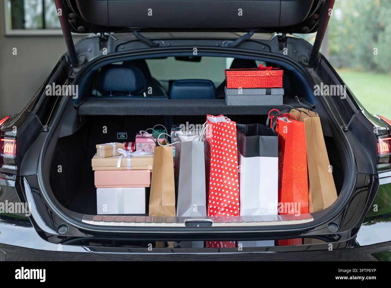 Bagagliaio aperto pieno di scatole regalo colorate e borse della spesa Foto Stock