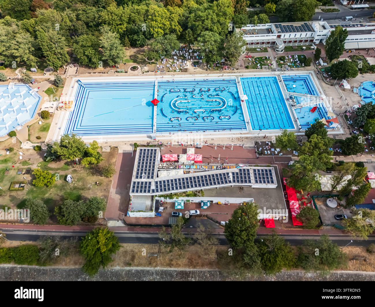 Vista aerea delle piscine e scivoli d'acqua del lido Palatinus sull'isola Margaret, Budapest, Ungheria, con nuotatori, sdraio, edifici della piscina e su Foto Stock