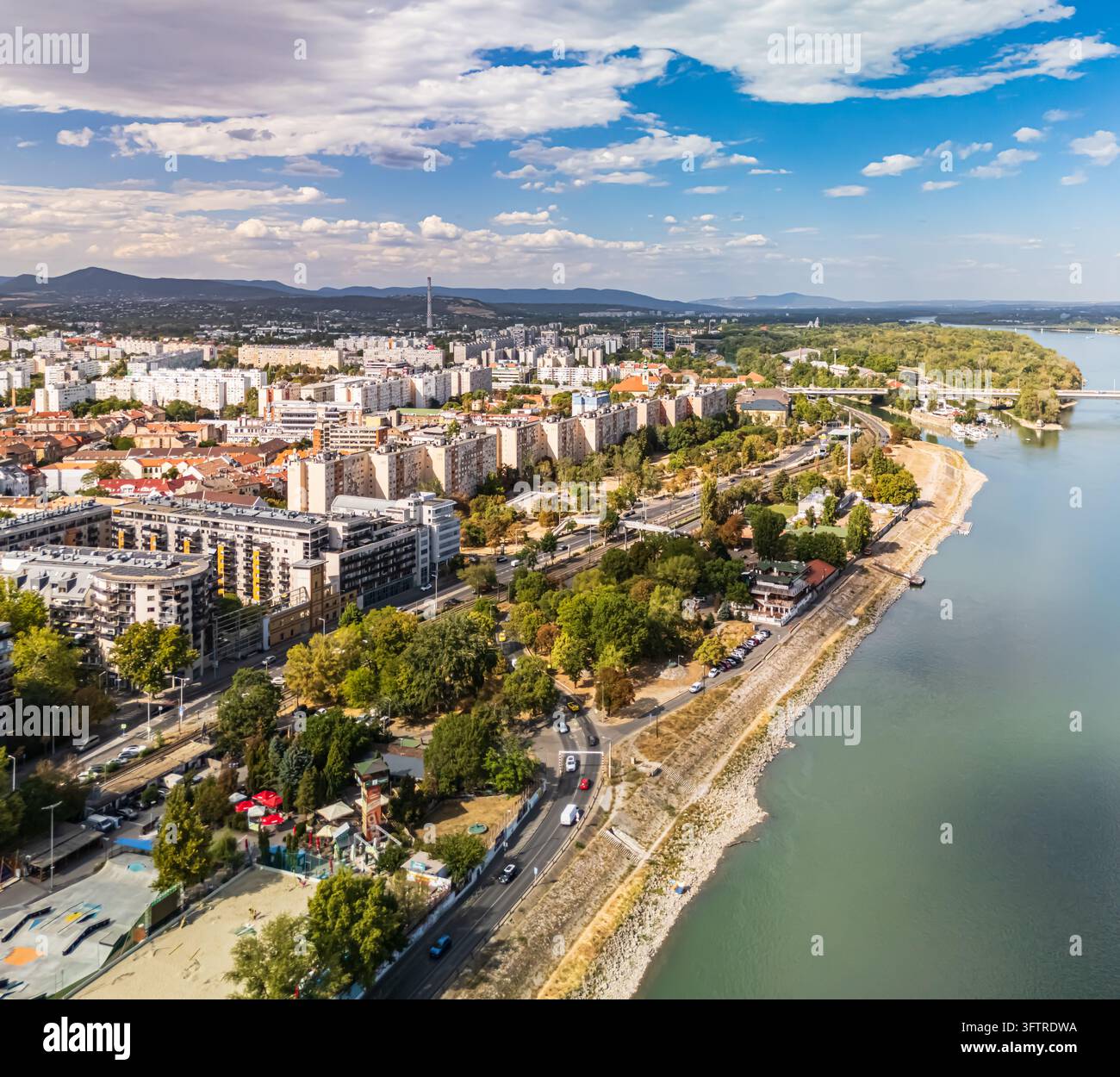 Vista aerea di blocchi di appartamenti residenziali e strade lungo il Danubio a Óbuda, Budapest, Ungheria, con ponti, rive verdi e la Buda H Foto Stock