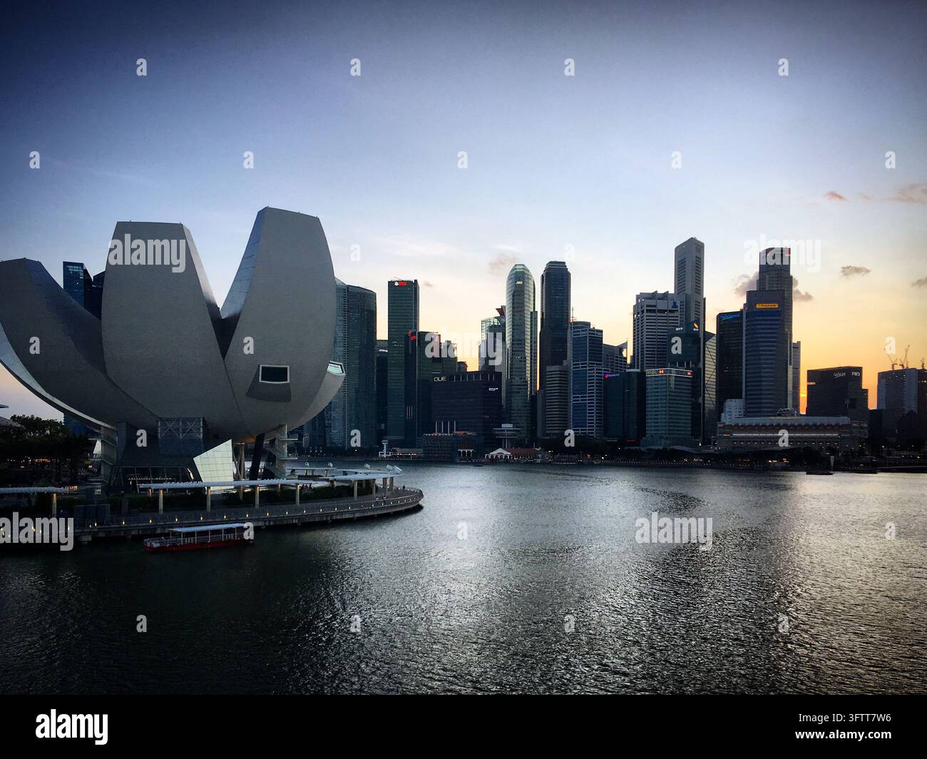 Il museo ArtScience a forma di loto si trova accanto alla Marina Bay di Singapore, i suoi pallidi petali svasati si protendono sopra la passeggiata sul lungomare. Dall'altra parte del Foto Stock