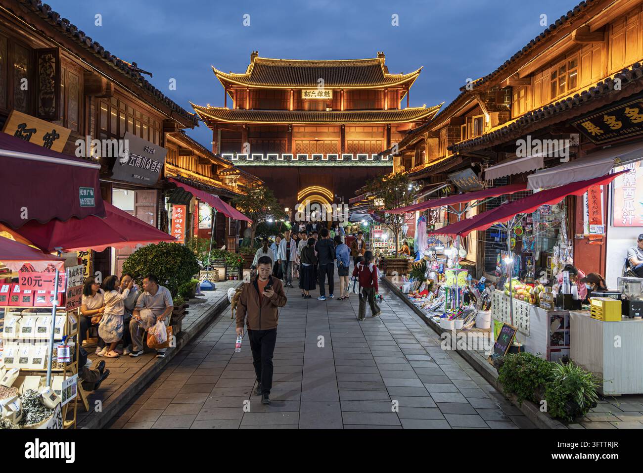 Dali, Cina - 06 ottobre 2026: Vista del cancello storico della vecchia città di Weishan, che mostra un'architettura tradizionale in legno, vetrine illuminate, Foto Stock