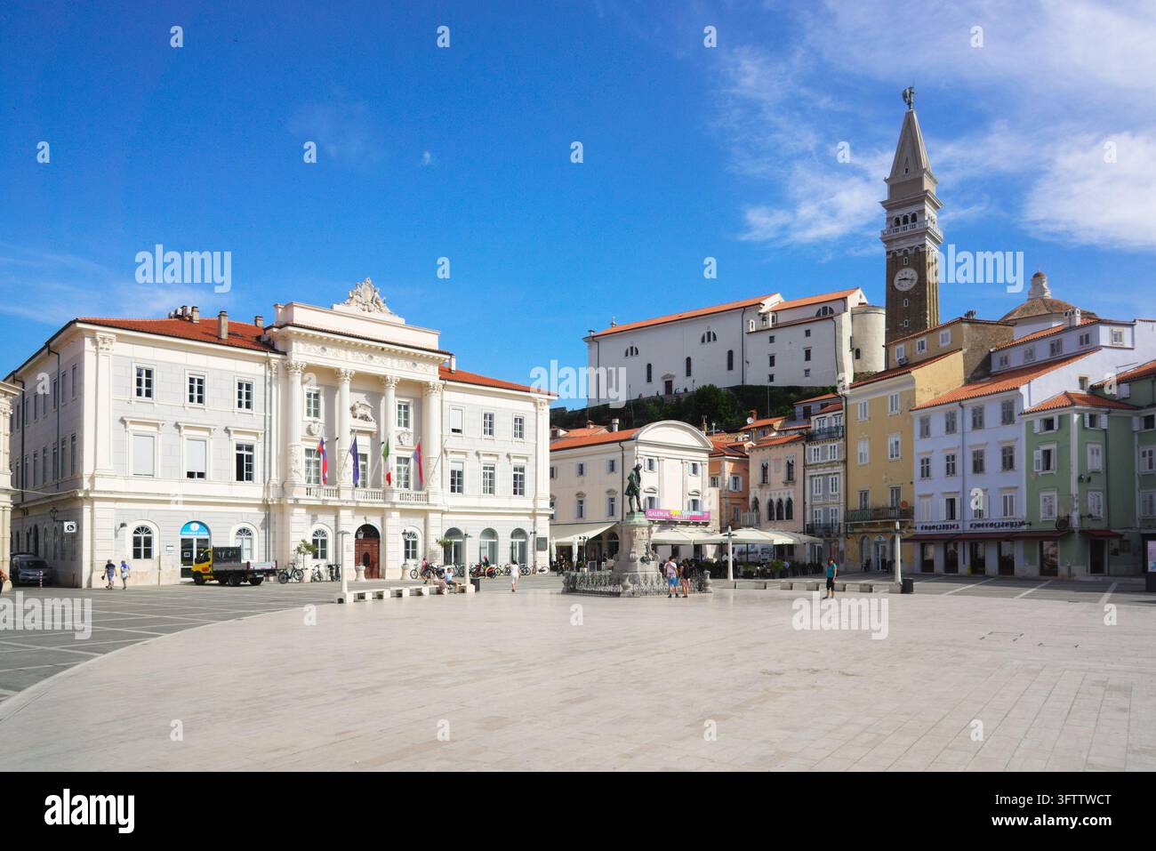 Piazza Tartini con Municipio e Campanile di San Giorgio a Pirano, Slovenia, sotto un cielo blu limpido. Foto Stock