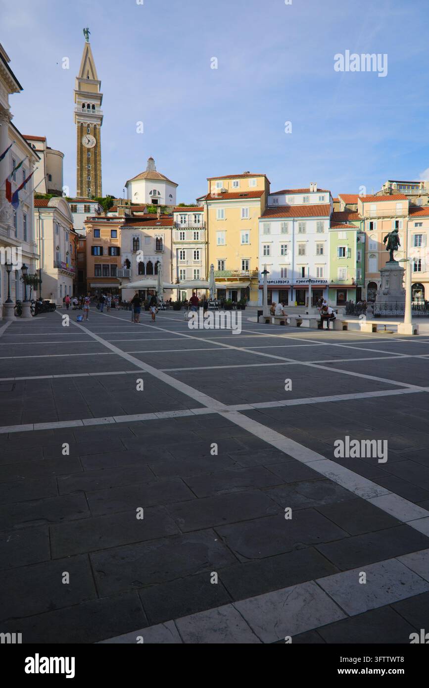 Piazza Tartini con piazza in pietra lastricata, facciate veneziane storiche e il campanile di San Giorgio a Piran, in Slovenia. Foto Stock