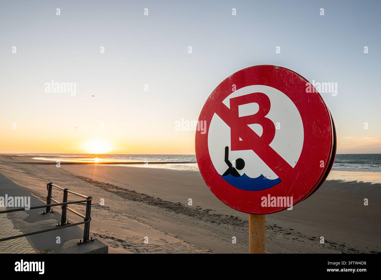 Segnale "Divieto di nuoto" sulla spiaggia al tramonto, costa belga Foto Stock