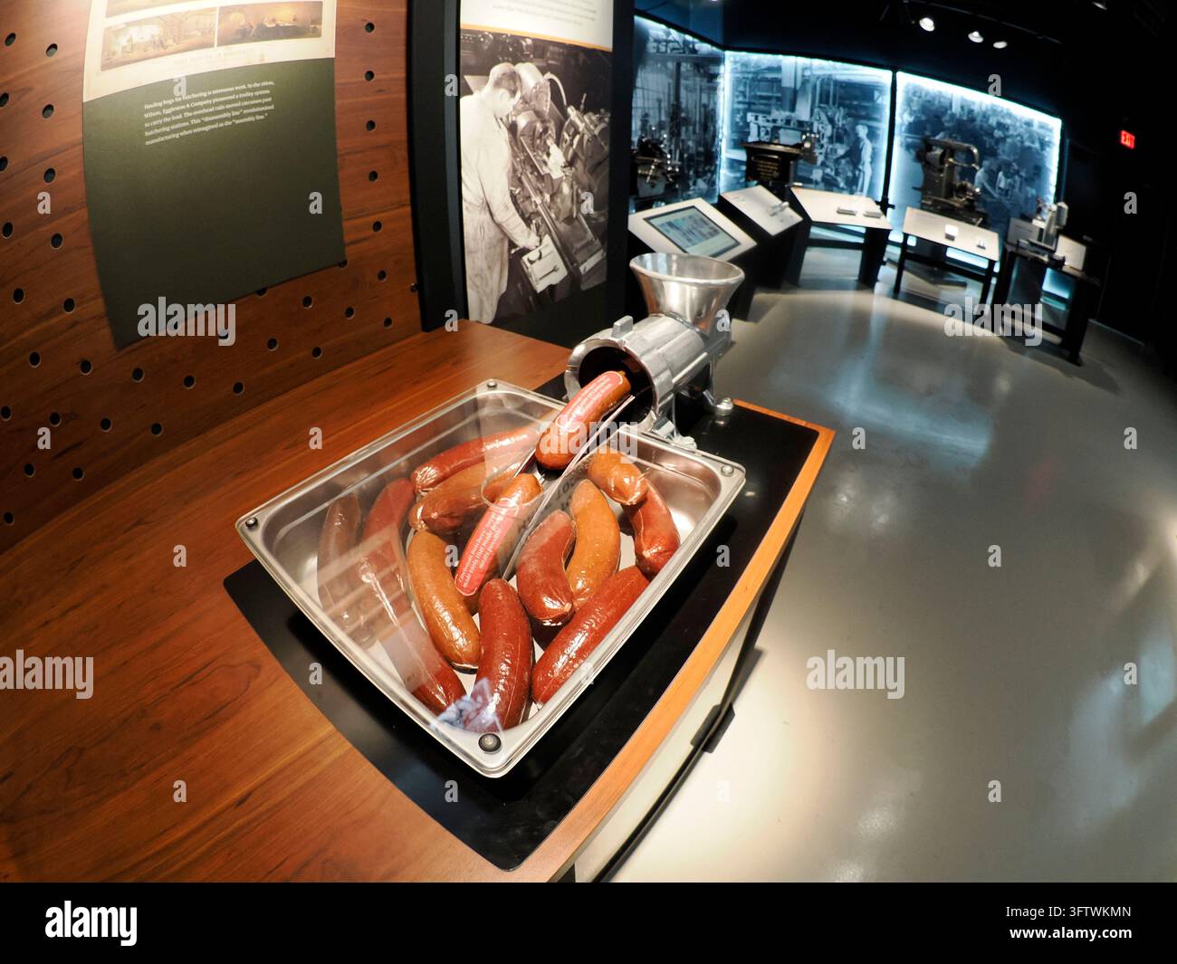 CINCINNATI, USA - 6 SETTEMBRE 2024: Esposizione museale con una replica di tritacarne e salsicce di plastica in un vassoio, che mostra l'industria storica dell'imballaggio della carne Foto Stock