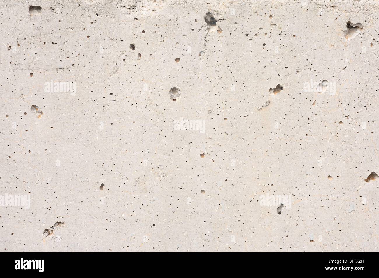 Texture di muro in cemento grigio chiaro con fori porosi e superficie di cemento ruvida e consumata. Foto Stock