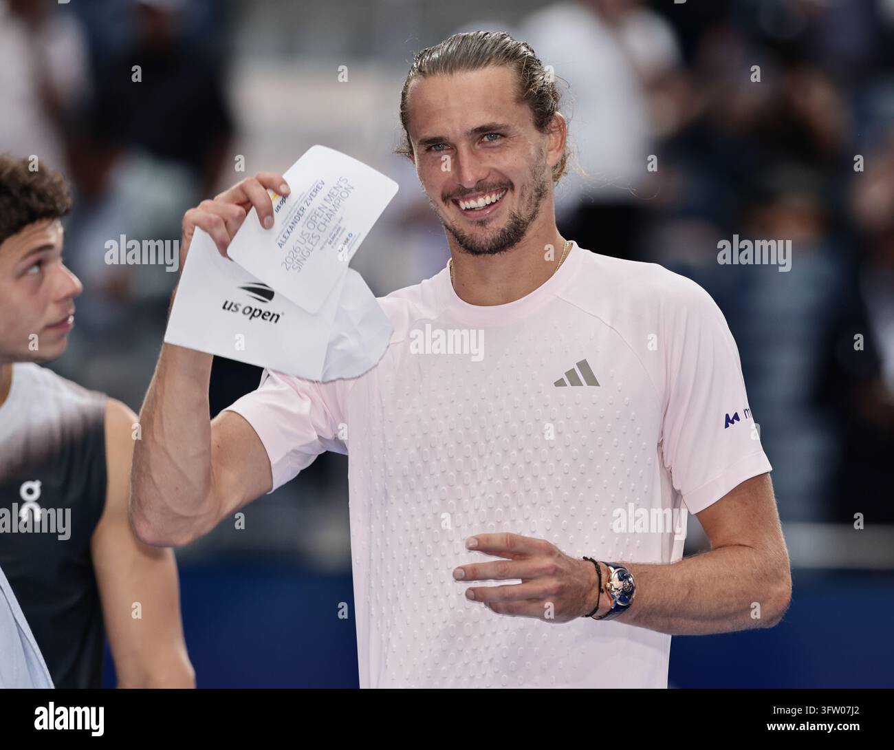 Alexander Zverev (GER) che solleva l'assegno dei vincitori alla cerimonia di premiazione dei campionati US Open 2026, USTA Billie Jean King National Tennis Center Foto Stock