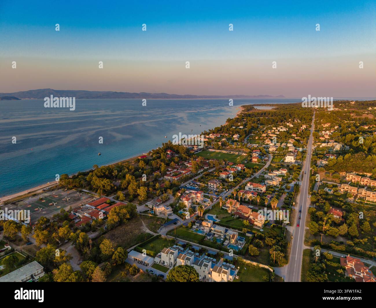 Spiaggia, strada e ville nella luce della sera, Pefkochori, Calcidica, Grecia Foto Stock