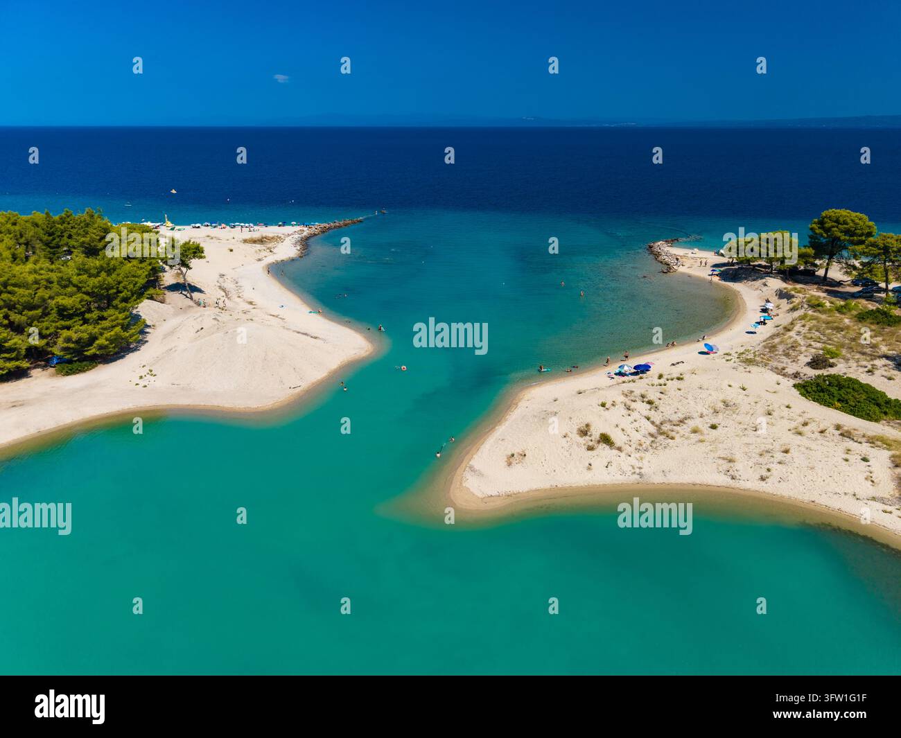 Acqua della laguna che incontra il mare blu profondo a Glarokavos, Calcidica, Grecia Foto Stock